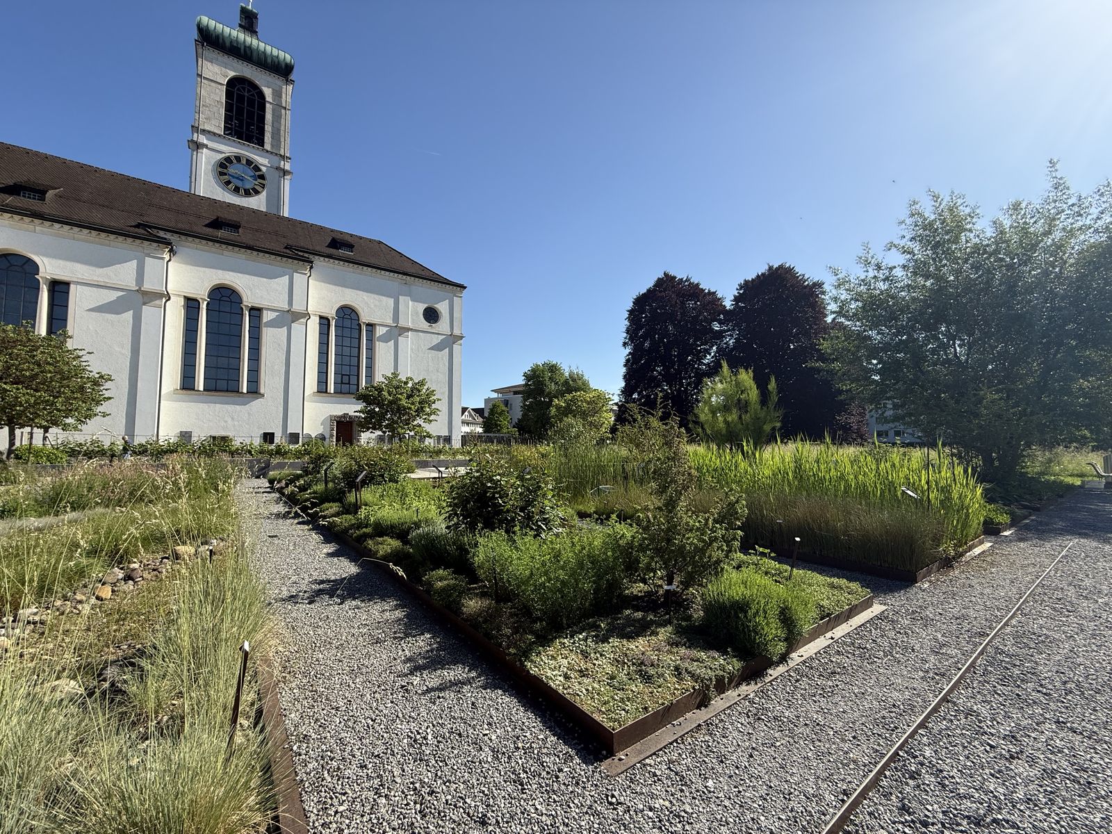 Kirche mit Bibelgarten im Sonnenlicht